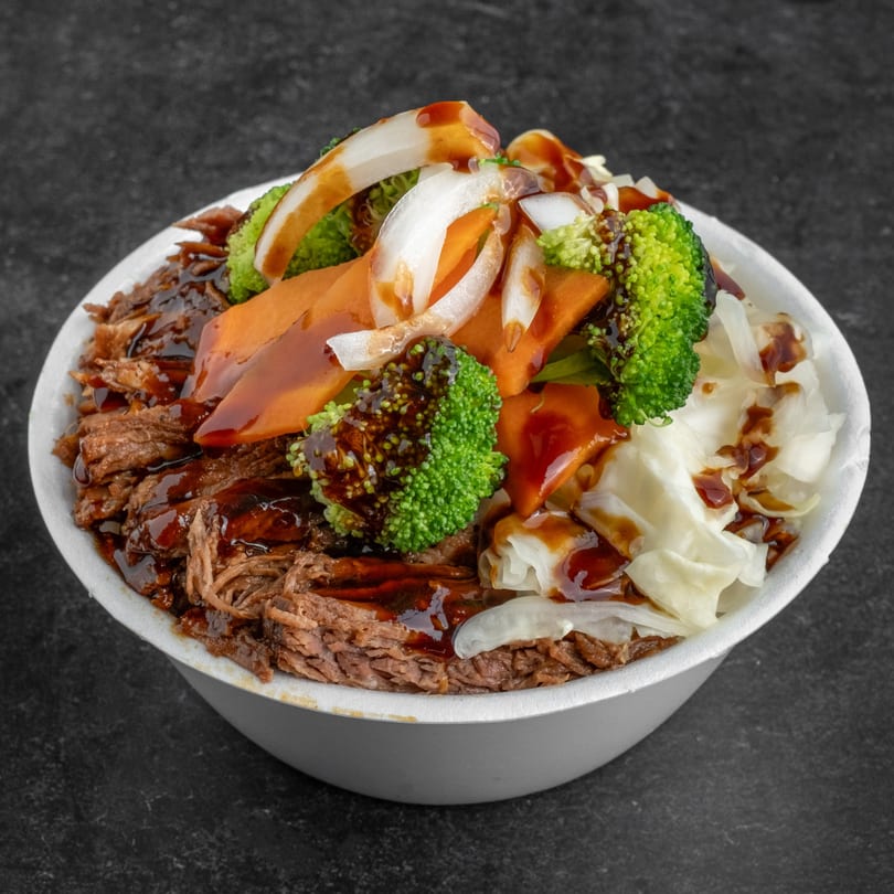 B & C Teriyaki's beef teriyaki bowl with broccoli, carrots, onions, and cabbage, drizzled with sauce.